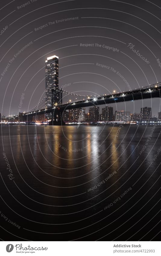 Bridge over river against skyscrapers at night time bridge water building city urban architecture cityscape multistory downtown modern dark obscure murk