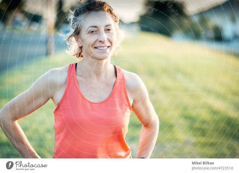 Real young mature caucasian woman in a sport wear in the park on a sunny afternoon. lifestyle training health fitness female healthy smiling real people resting