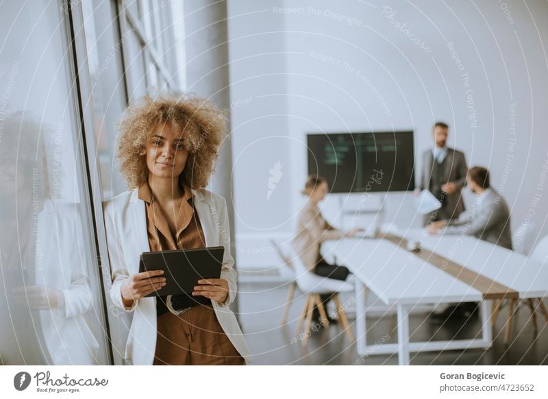 Young businesswoman using digital tablet in the office with young people works behind her accounting businessman casual caucasian communication conversation