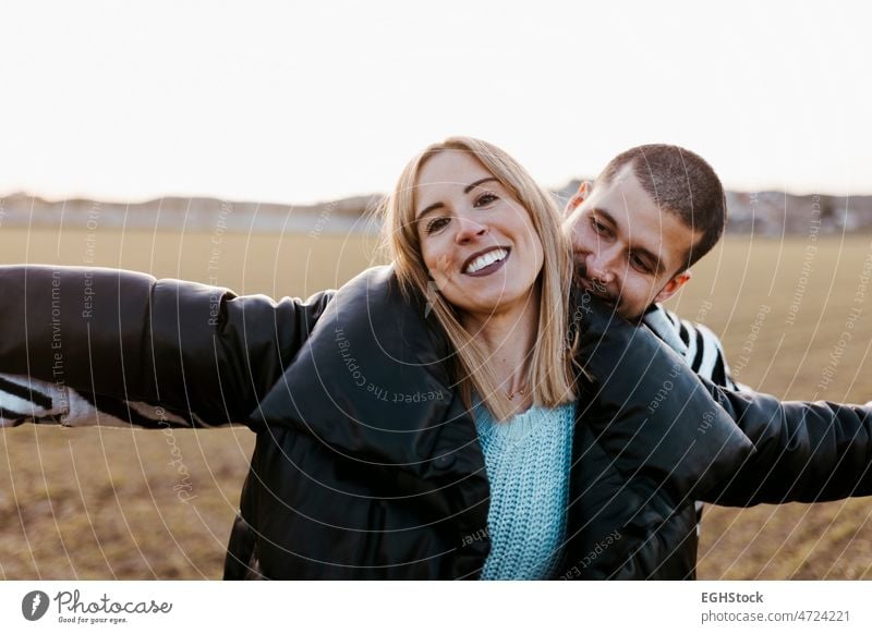 Young couple dancing outdoor through meadow in countryside. journey weekend people man woman adult nature outdoors affectionate bonding embracing enjoying