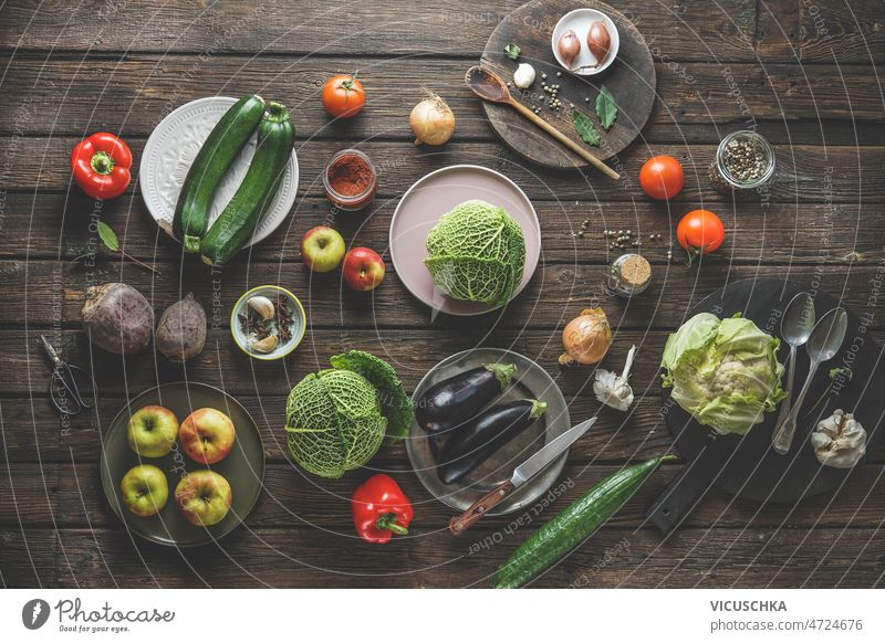 Various vegetables and fruits on rustic wooden kitchen table various brown zucchini apples cucumber beetroot cauliflower cabbage tomatoes herbs spices healthy