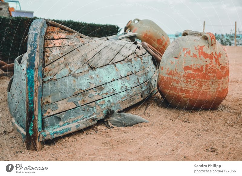 Old wooden boat lying on the beach between clay pots wreck Watercraft Fishing boat Navigation Exterior shot Colour photo Deserted Day Ocean Wood Blue Rowboat