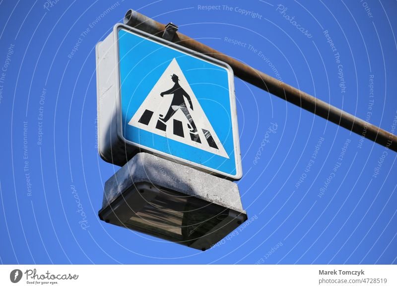 Hanging sign crosswalk. Blue sky as background. traffic sign Pedestrian street lamp Street lighting Exterior shot Day Colour photo Pedestrian crossing Sky