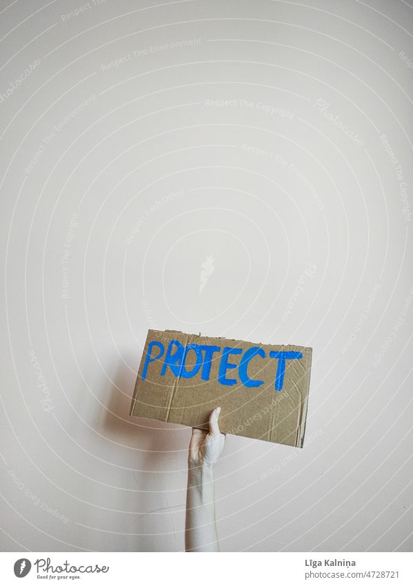 Hand holding cardboard sign with word protect Sign Cardboard Characters Protect Protest Demonstration protest Politics and state demonstrate Respect Solidarity