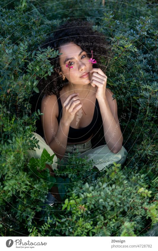 A beautiful long-haired brown-haired woman stands on a background of exotic plants person model female portrait young beauty fashion flower girl nature face