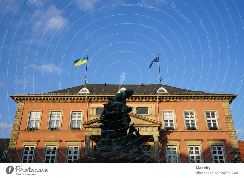 The flag of Ukraine against blue sky in the sunshine on the town hall of Detmold on the market square with the Donop fountain in East Westphalia Lippe Flag