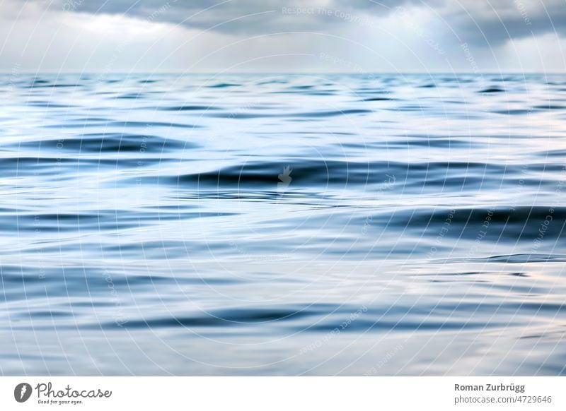 Rain clouds over calm waters Waves Water wave Surface of water element water circuit Pure neat Liquid texture background Sky silent tranquillity Ocean Lake