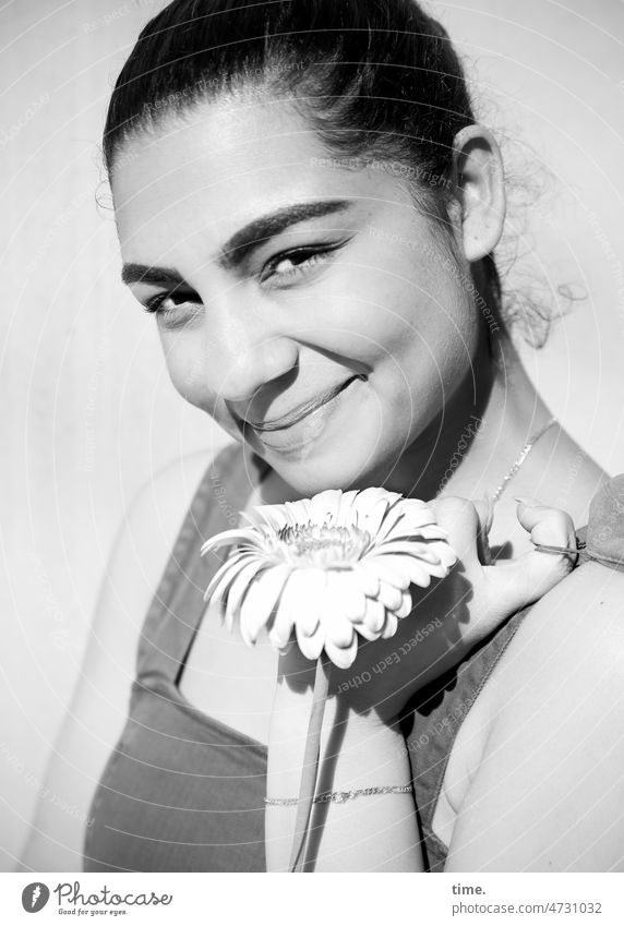 Woman with flower Flower feminine Smiling sunny Braids Looking into the camera Spring Dark-haired