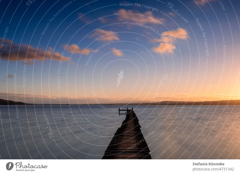 Atmospheric sunset at lake Ammersee Lake Ammer Sunset Long exposure Twilight Evening Deserted Footbridge bank Colour photo Exterior shot Dusk Contentment