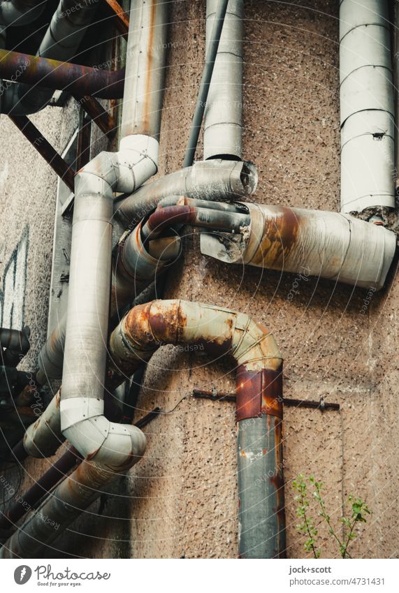 Pipe burst due to rust conduit house corner Broken Plaster Part Decline Derelict Out of service reeds Apocalyptic sentiment flexed Structures and shapes