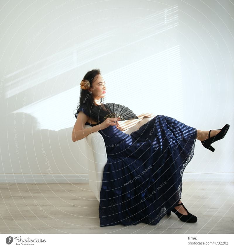 Woman in a room looking at the sunlight Elegant Dress Dark-haired Jewellery portrait Sit Armchair Colour Guide Profile Long-haired Curl Strip of light Shadow