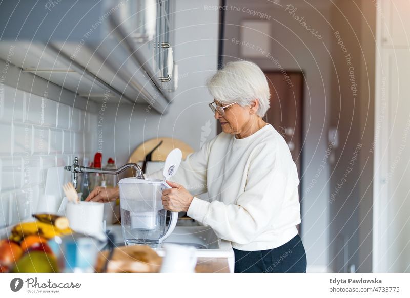 Shot of a senior woman in her kitchen alone at home domestic life elderly female grandma grandmother grey hair house indoors lifestyle mature old older