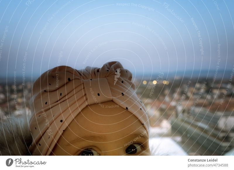 Child with pink cap in front of city with evening sky Baby Toddler eyes brown eyes dark eyes Girl Face Infancy portrait Cute little girl Curiosity Enchanting