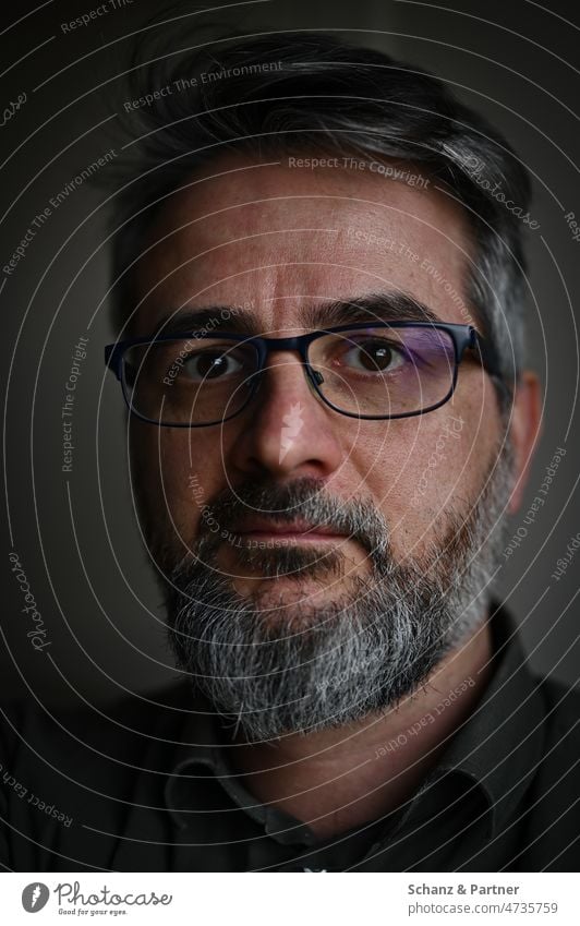 serious face of man with glasses and beard Face Earnest Facial hair gray hair Dark sad gloomy depressive depression Looking Looking into the camera portrait