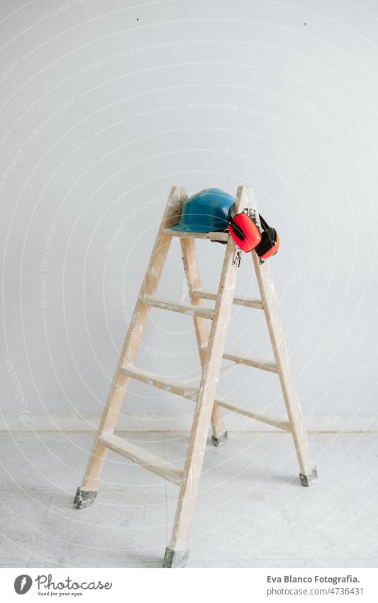 ladder, blue protective helmet and ear defenders at construction site. Home improvement, renovation protection helmet real state home works contractor expertise