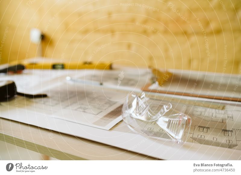 blueprints, ear defenders, protection glasses and tools on architect workspace at construction site home level meter insulating real state house yellow table