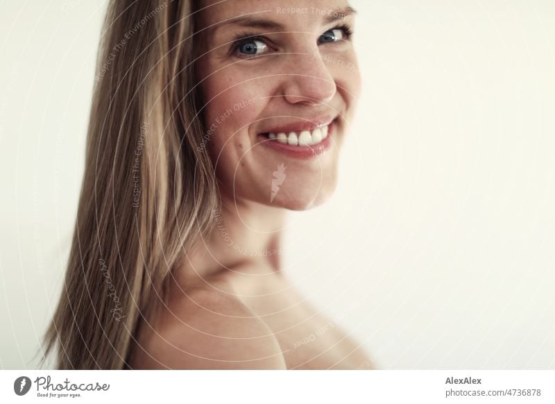 side portrait of young tall blonde woman with ponytail hairstyle and dimples smiling at camera Close-up Youthfulness look long hairs Emanation Expectation