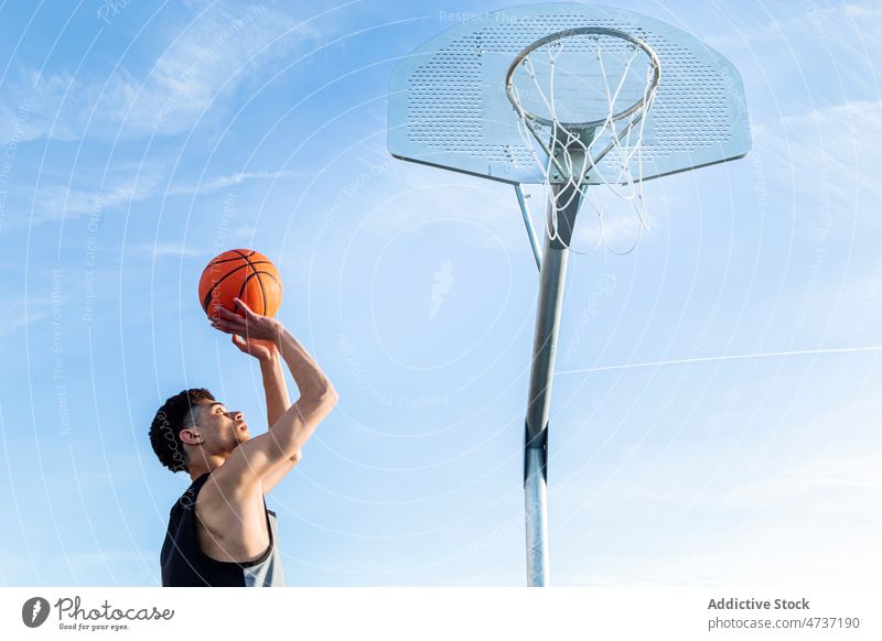 Faceless man throwing ball in hoop sportsman basketball game play score training goal blue sky player hobby streetball challenge athlete activity male summer