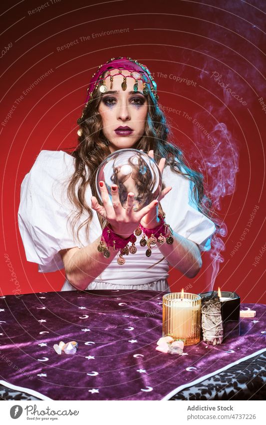 Soothsayer telling fortunes with magic ball woman soothsayer fortune teller predict crystal candle conjure supernatural portrait mystic future female guess