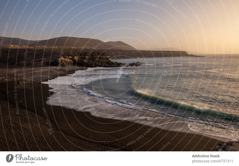 Sandy beach and rocky coast washed by ocean wave seascape sand nature volcanic cliff island scenery formation foam seashore geology exotic europe canary islands