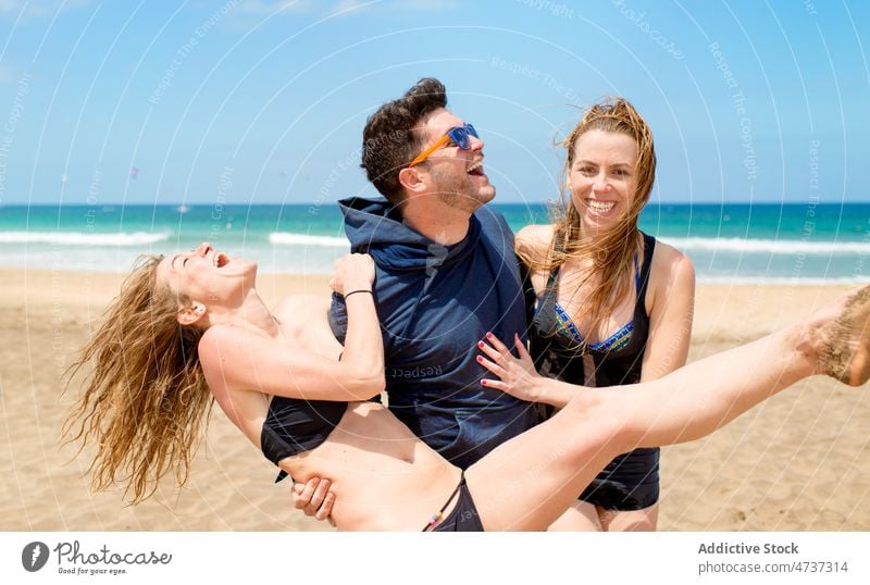 Cheerful friends having fun on sandy beach during vacation man women laugh joy happy sea female seashore cheerful coast flying hair excited enjoy delight