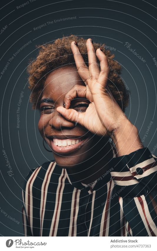 Smiling black woman showing OK gesture in studio ok portrait sign positive symbol childish good playful female happy expressive cheerful optimist glad