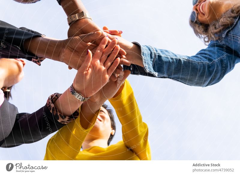 Positive friends stacking hands together group friendship street city bonding pastime spend time stack hands relationship join hands cheerful optimist joy