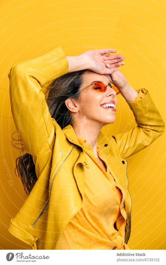 Smiling modern woman with long flying hair in studio happy motion flowing hair style cool bright pleasant wind carefree female model editorial appearance