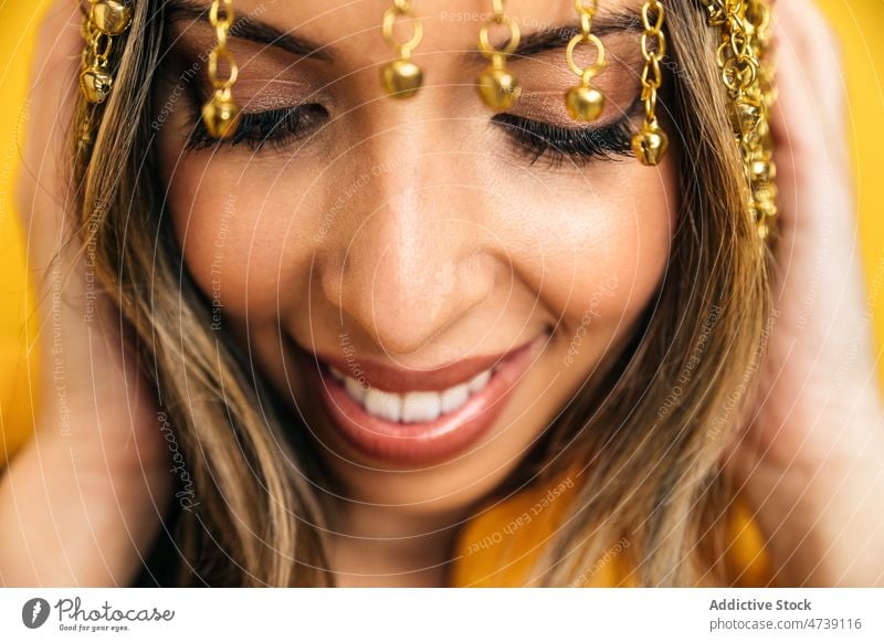 Charming woman wearing tassel headband in studio portrait style individuality cool cheerful makeup chain female editorial model optimist positive smile