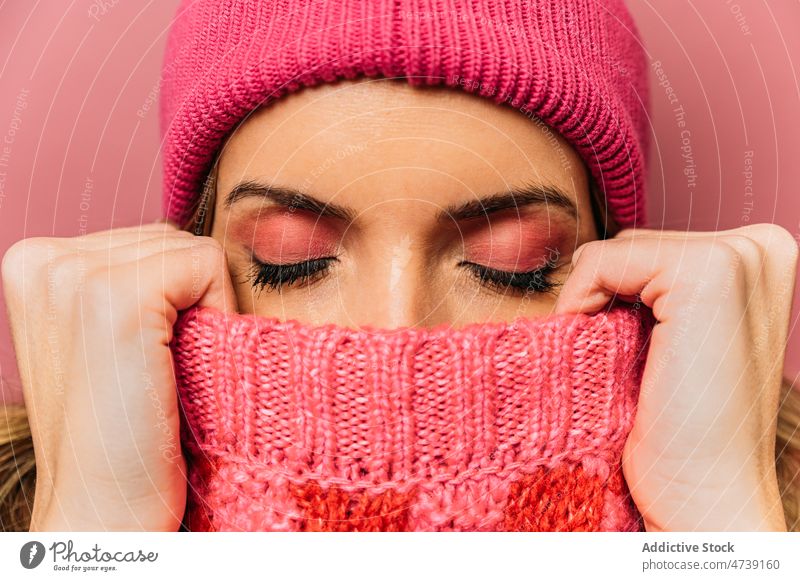 Woman covering face with sweater woman style cover face hide design female fashion feminine shy knitted hat trendy studio knitwear lady calm appearance model