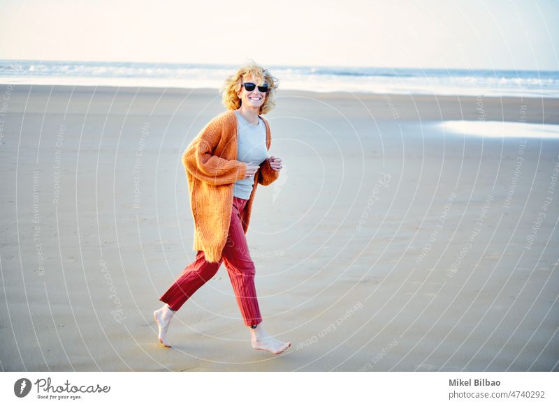 Young mature blonde caucasian woman running outdoor in a beach in a sunny day.  Lifestyle concept. lifestyle portrait wellness women healthy joyful active