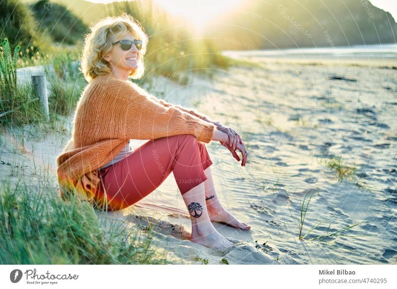 Young mature blonde caucasian woman relaxing outdoor with a tablet in a sunny day. lifestyle portrait women healthy one person lifestyles enjoy female ethnic