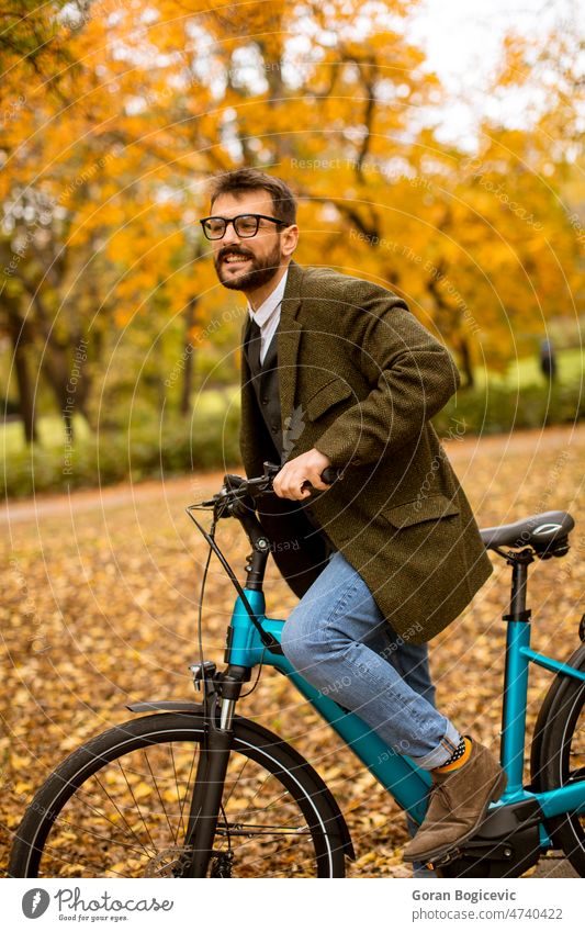 Young man with electric bicycle in the autumn park young nature lifestyle outdoor activity color ride summer bike day leisure people ebike travel sport city