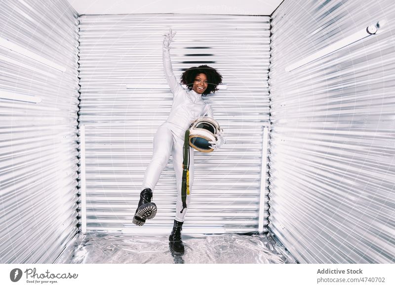 Black astronaut showing peace gesture woman spacesuit helmet spaceship cosmonaut happy costume smile victory profession mission glad uniform modern celebration