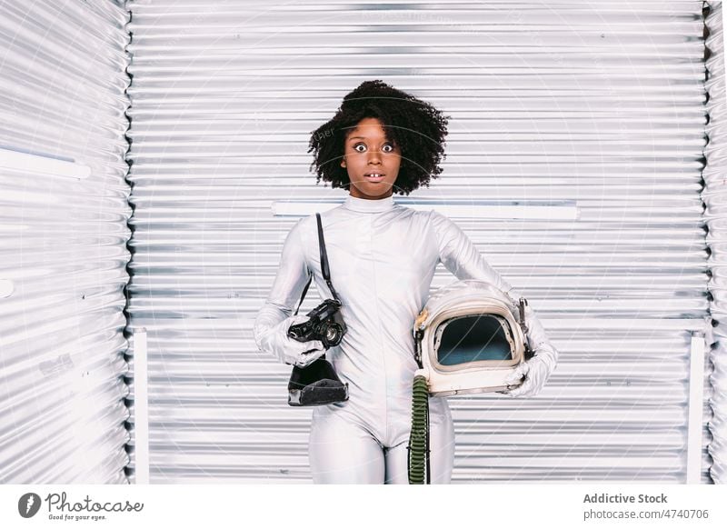 Astonished black woman in astronaut costume spacesuit amazed helmet photography camera photographer spaceship cosmonaut mission uniform vintage surprised modern