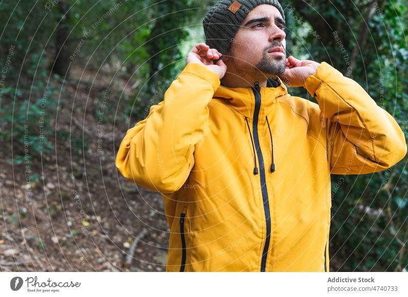 Man in wool cap walking in forest man hiker nature trekking tree journey explore trip woods activity adventure beard male explorer environment serious hat