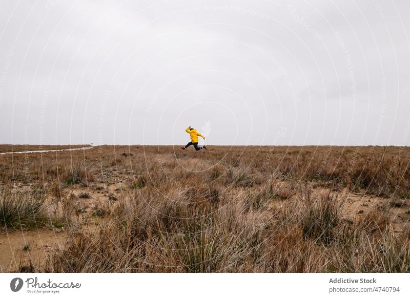 Person jumping in grassy field person carefree nature journey leisure pastime recreation activity freedom trip countryside meadow adventure active terrain move