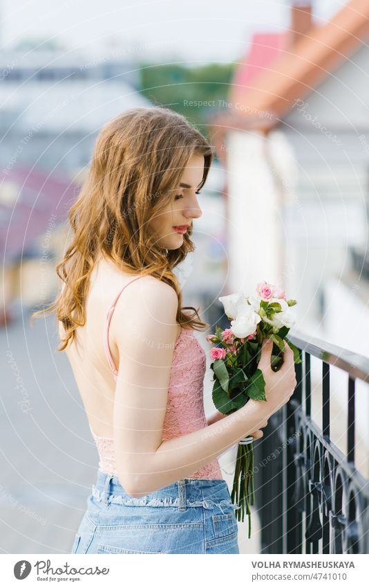 A beautiful young girl in light clothes holds a bouquet of roses in her hands person beauty flower woman smile portrait adult fashion background spring model