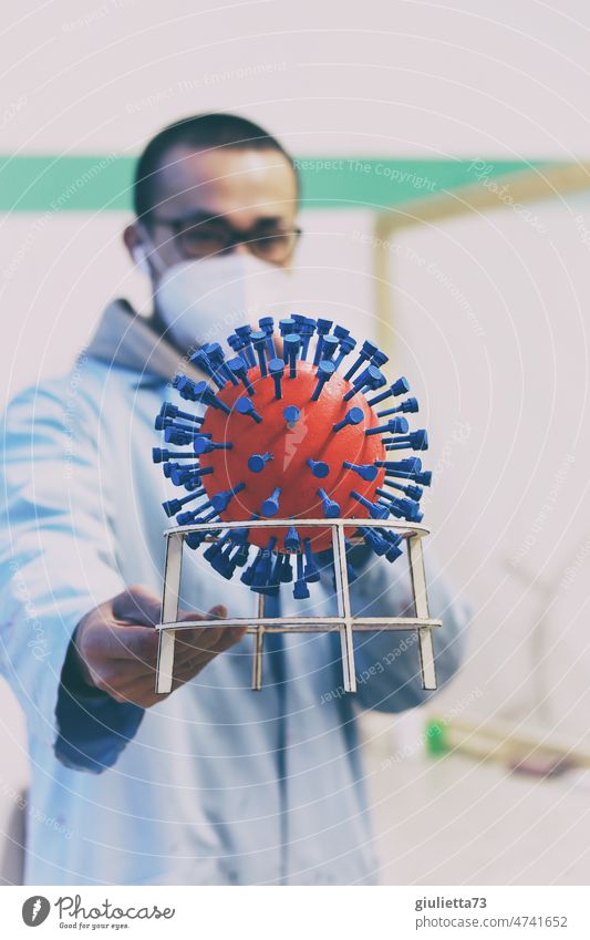 corona thougts | From the lab? Young man with mouth-nose protection holds a virus model in his hand portrait Human being Man 3D model Virus Corona virus