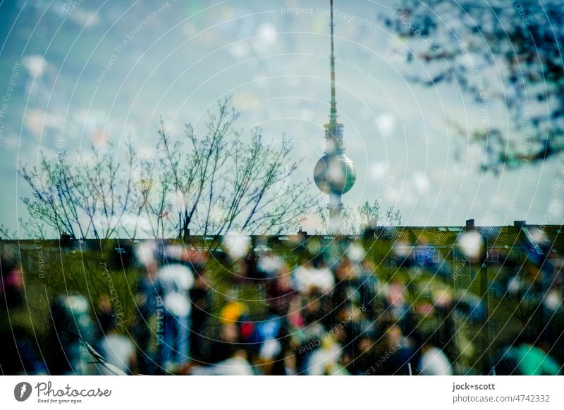 many people are walking in the Berlin park or sitting on the green areas wall park Silhouette Illusion Reaction Berlin TV Tower Landmark Tourist Attraction