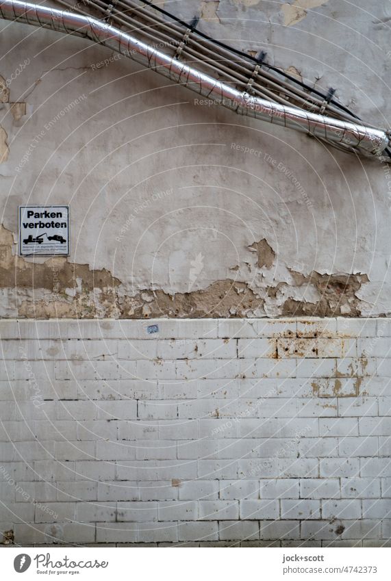 Tiles, pipe, cable and chipped plaster in parking prohibited Pipe forbidden Old Ravages of time Decline Broken Structures and shapes Change Signage no parking