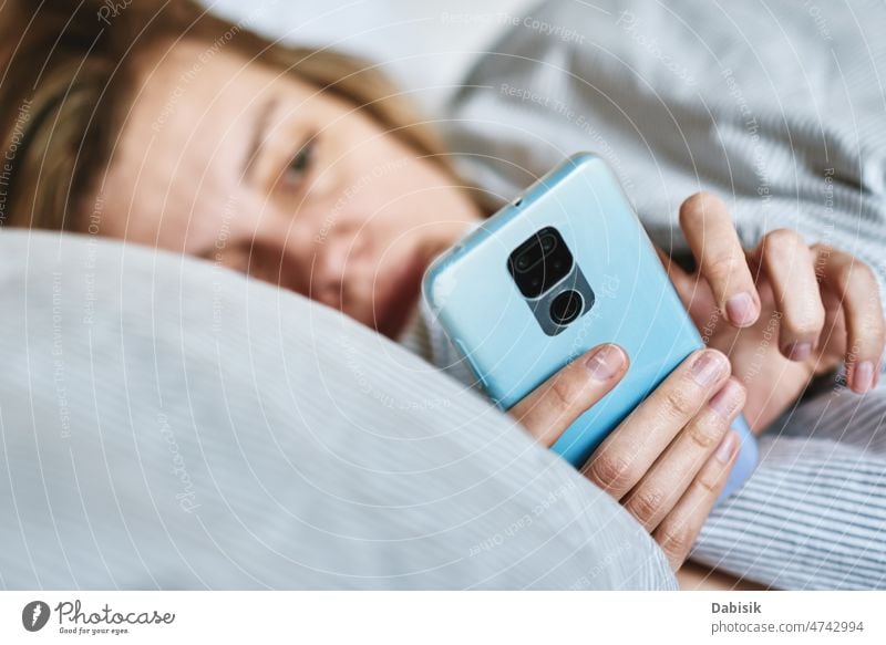 Woman using smartphone in the bed, Social media, Lazy weekend woman morning online relax hold lazy social screen cell time sleep chat tired girl mobile