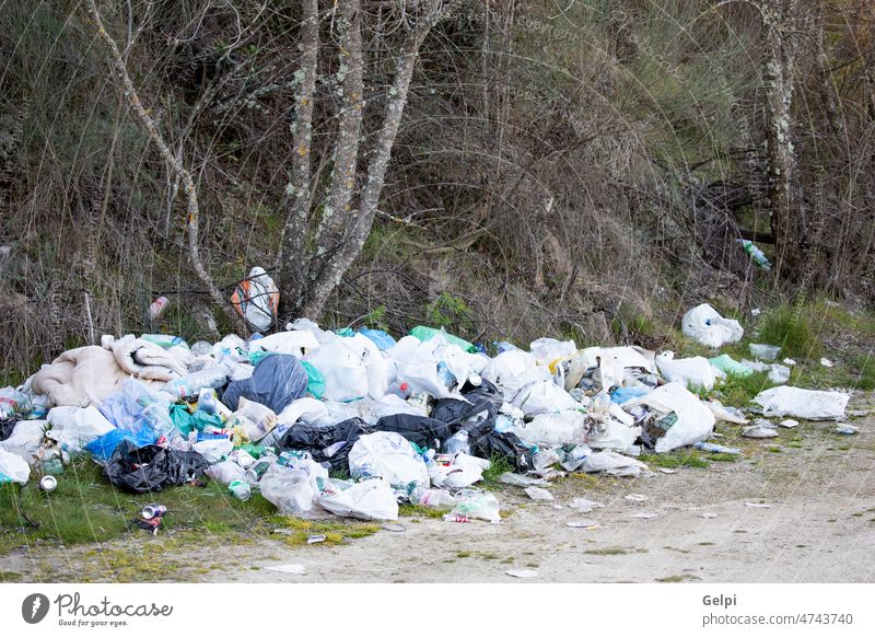 A garbage dump in a rural field. pollution waste plastic trash ecology full rubbish litter countryside environment recycling container pile bin disposal dirty