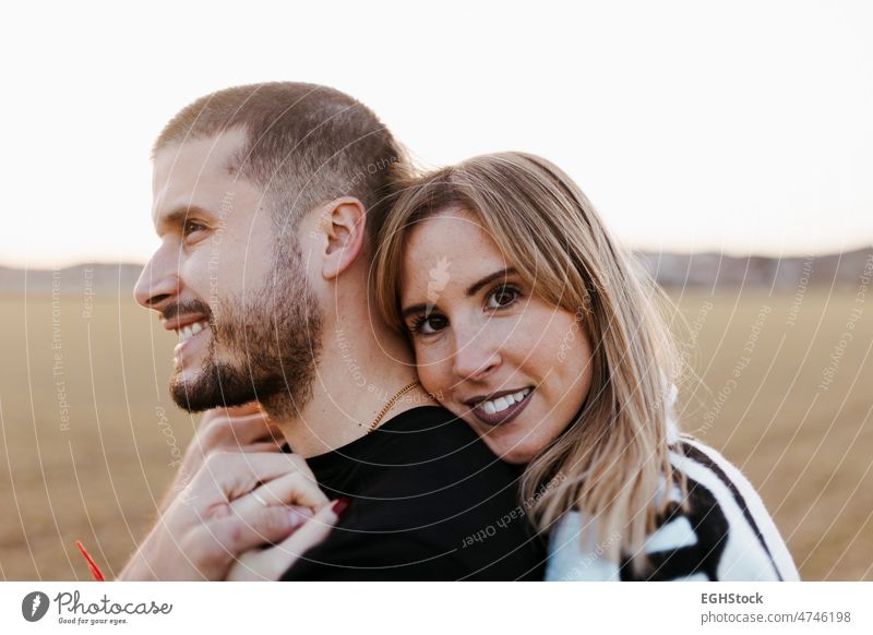 Close up couple hugging and looking at camera in the countryside embraced. Boyfriend and girlfriend in love close up two people embracing journey weekend man