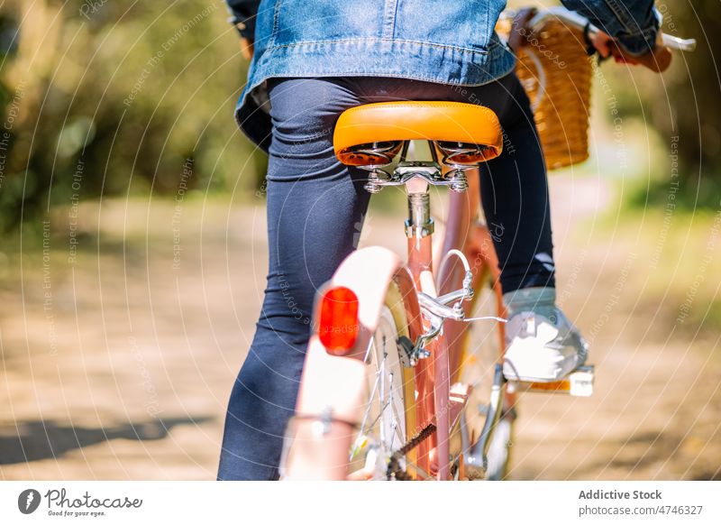 Anonymous kid riding bicycle on path park hobby leisure pastime childhood recreation ride activity summer bike transport summertime plant cute adorable