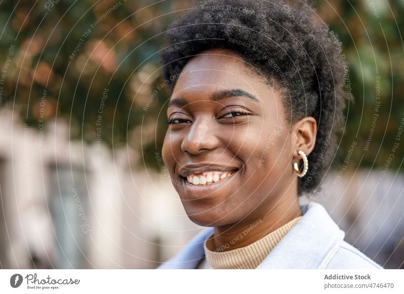 Smiling black woman in city street appearance style feminine enjoy urban smile building african american female summer glad happy casual positive content