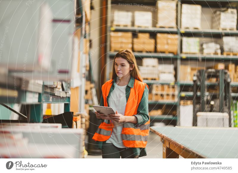 Woman with tablet in factory storehouse checking location of goods business cargo confident delivering delivery distribution employee female industrial industry