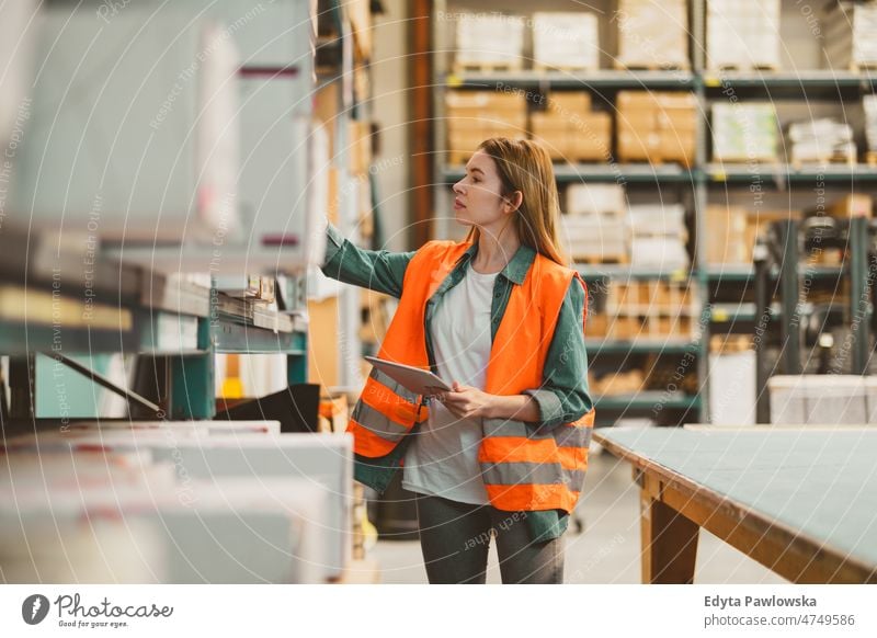 Woman with tablet in factory storehouse checking location of goods business cargo confident delivering delivery distribution employee female industrial industry