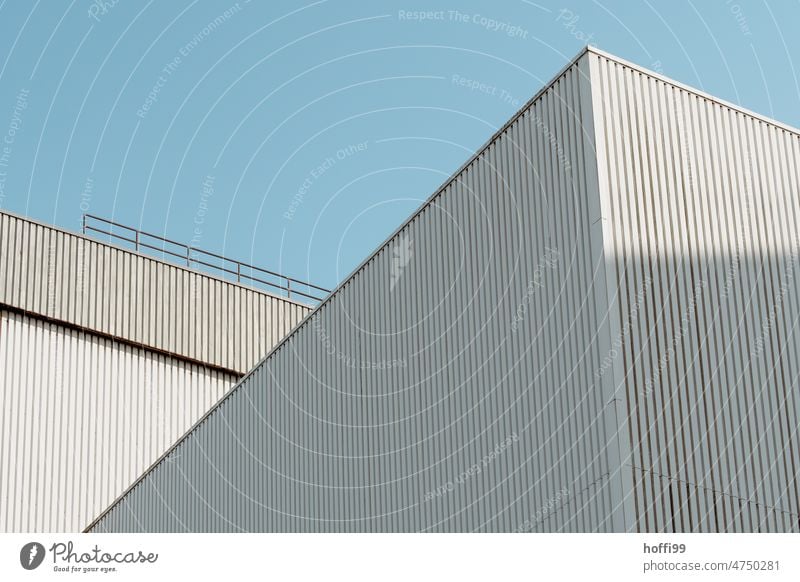 White corrugated metal facades of warehouse in harbor against blue sky Architecture Harbour industrial facade Blue sky Storage Flake Corrugated sheet iron