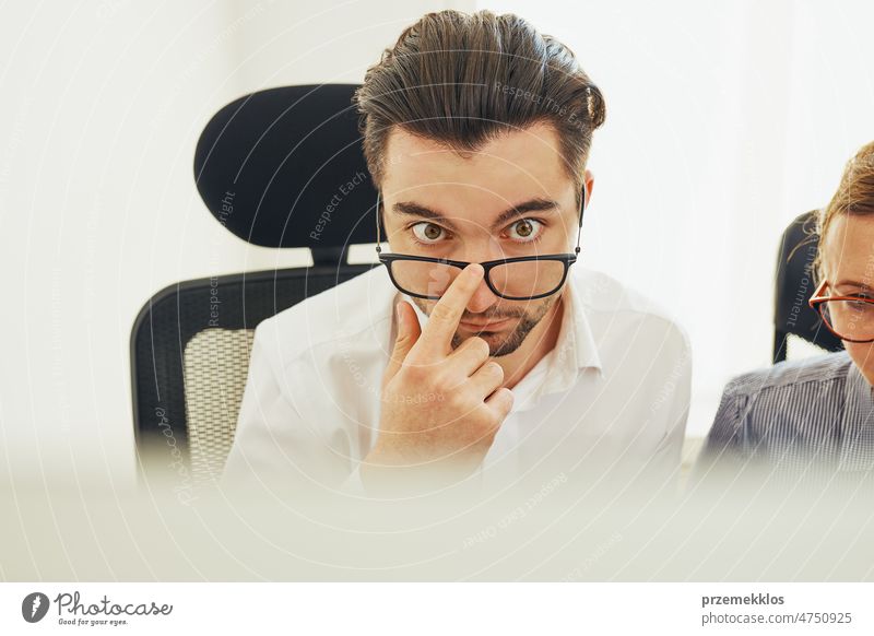 Two business people discussing financial data looking at computer screen. Entrepreneurs working hard sitting at computere screen in office. People having deadline working together